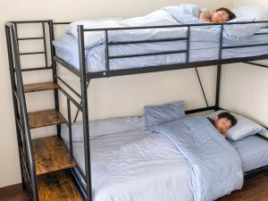 two people laying on top of bunk beds at 宿のきむら2 in Utsunomiya