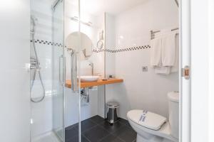a bathroom with a shower and a toilet and a sink at OTTIUM Albanuracín in Albarracín