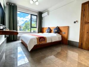 a bedroom with a large bed and a large window at 芮嘉民宿 阳朔西街店 in Yangshuo +24 photos