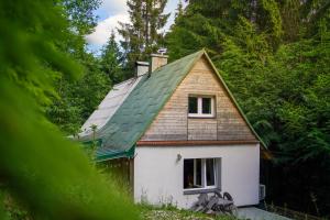 a small white house with a green roof at Mama Chata a Mama Spa Beskydy in Bílá