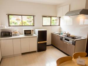 a kitchen with a refrigerator and a microwave at 宿のきむら2 in Utsunomiya