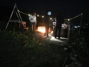a group of people standing around a fire at night at Fair Field Bungalow in Nuwara Eliya