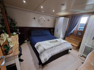 a bedroom with a bed and a mirror on the wall at Selene Unique Luxury Houseboat Experience in Chertsey