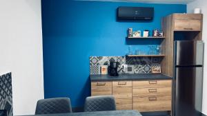 a kitchen with a blue wall and a refrigerator at Casa Azul in São Vicente +16 photos