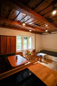 a living room with a table and a bed at Mama Chata a Mama Spa Beskydy in Bílá