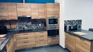 a kitchen with wooden cabinets and stainless steel appliances at Casa Azul in São Vicente