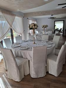 a dining room with a white table and chairs at Casa Roua Munților in Dămuc +6 photos