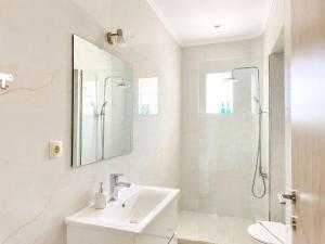 a white bathroom with a sink and a shower at Cretan Nature Stone Apartment in Ayiás Filakaí +21 photos
