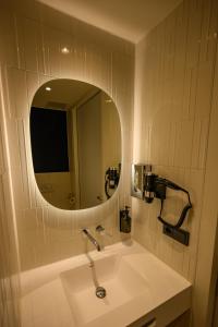 ein Badezimmer mit Waschbecken und Spiegel in der Unterkunft Hotel het Dok in IJmuiden + 44 Fotos
