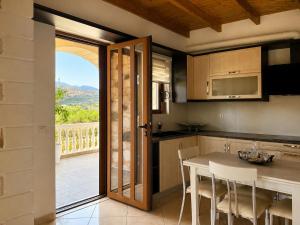a kitchen with a table and a view of a balcony at Cretan Nature Stone Apartment in Ayiás Filakaí