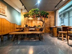 a room with a table with a tree in it at 芮嘉民宿 阳朔西街店 in Yangshuo