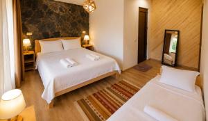 a bedroom with a large white bed and a mirror at Guest House Keti Margiani Mestia in Mestia