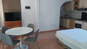 a small room with a bed and a table and chairs at Apartments Tomas in Ugljan +12 photos