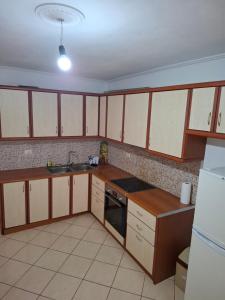 a kitchen with wooden cabinets and a sink and a refrigerator at Saranda porti in Sarandë +8 photos