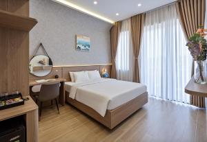 a hotel room with a bed and a desk at LUNA Hotel in Vĩnh Long +34 photos