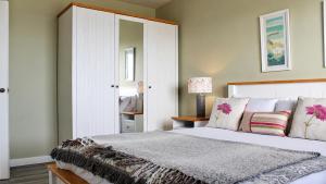 a bedroom with a large bed and a mirror at Dunmore East Ocean View Suite in Dunmore East