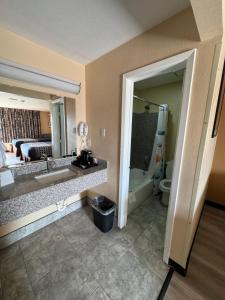 a hotel room with a bathroom with a sink and a tub at Villa West Inn in Odessa