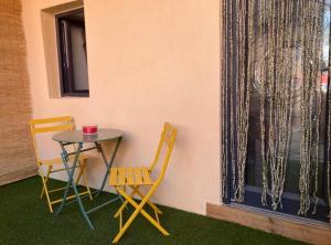 a table and two chairs and a table and a window at Studio LA PETITE PAUSE in Ajaccio