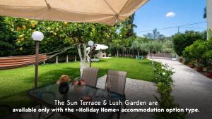 a table and chairs in a garden with an umbrella at Villa Nektaria in Nikiana