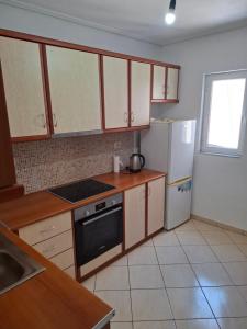a kitchen with wooden cabinets and a white refrigerator at Saranda porti in Sarandë