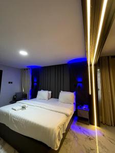a bedroom with a large white bed with blue lights at Kim Royal Hotel and Suites in Festac Town