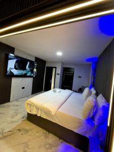 a bedroom with a large bed and a tv at Kim Royal Hotel and Suites in Festac Town