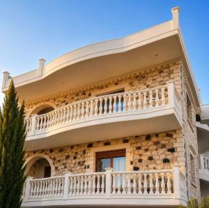a building with a balcony on the side of it at Cretan Nature Stone Apartment in Ayiás Filakaí