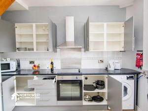 a kitchen with white cabinets and gray counters at Comfy 2-Bedroom Family & Contractor Home in Bolton with Free Wi-Fi and Street Parking By North West Accommodation in Bolton