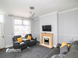 a living room with a fireplace and a tv at Comfy 2-Bedroom Family & Contractor Home in Bolton with Free Wi-Fi and Street Parking By North West Accommodation in Bolton