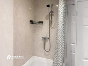 a bathroom with a shower and a tub at Comfy 2-Bedroom Family & Contractor Home in Bolton with Free Wi-Fi and Street Parking By North West Accommodation in Bolton