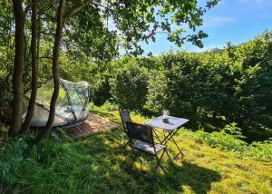 a table and a chair in the grass with a tub at La Noisette Basque - Nuits au verger in Saint-Pée-sur-Nivelle +6 photos