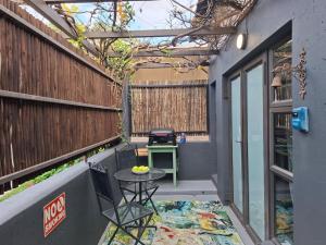a small patio with a table and a grill at A Little Guesthouse in Bloemfontein