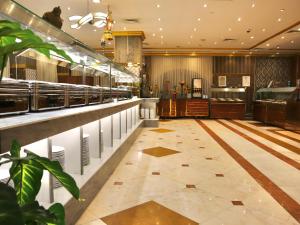 a restaurant with a long counter and a bar at Zowar Alalami Hotel - فندق زوار العالمي in Medina