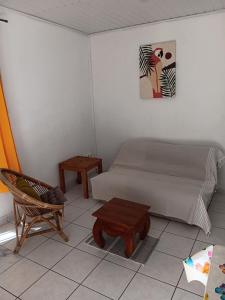 a bedroom with a bed and a chair and a table at L'îlot vacances in Saint-Pierre