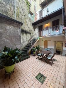 a patio with a table and chairs and stairs at Casa Raste in Lecco