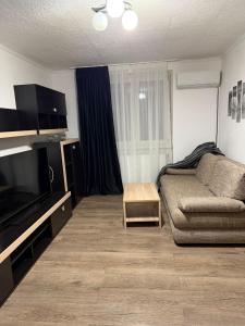 a living room with a couch and a flat screen tv at GZP Residece Lugoj 22 in Lugoj