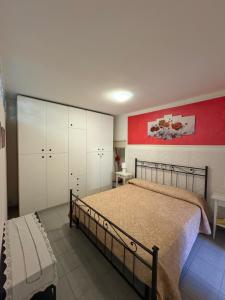 a bedroom with a large bed and a red wall at Casa Raste in Lecco