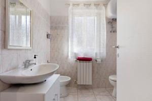 a white bathroom with a sink and a toilet at Lola House tra Alghero e Stintino in Palmadula +14 photos