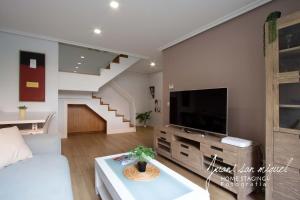a living room with a tv and a staircase at Casa Alma in Villamediana de Iregua