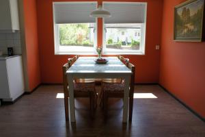 a dining room with a table and some orange walls at Gårdsjö 7 in Gårdsjö