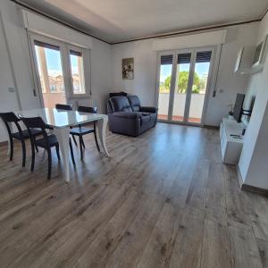 a living room with a table and chairs and a couch at Appartamento Scossicci in Porto Recanati