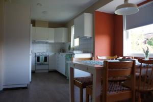 a kitchen with a table and chairs and a kitchen with white cabinets at Gårdsjö 7 in Gårdsjö