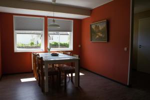 a dining room with orange walls and a table and chairs at Gårdsjö 7 in Gårdsjö