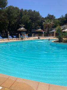 a large swimming pool with blue water in a resort at Chalet Cannelle Spa camping Buffalo Hacienda in La Seyne-sur-Mer