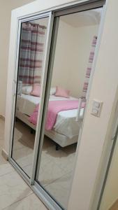 a reflection of a bedroom with a bed and a mirror at Katty House in Santa Bárbara de Samaná