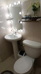 a bathroom with a white toilet and a sink at Katty House in Santa Bárbara de Samaná