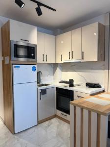 a kitchen with a white refrigerator and a microwave at Azur Properties 74 in Shkorpilovtsi