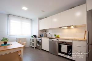 a kitchen with white cabinets and a table at Casa Alma in Villamediana de Iregua