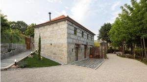 a small stone building in a yard with trees at Villas Santo António in Baião