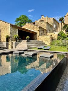 a swimming pool in front of a building at Domaine de Ribaute in Lieuran-lès-Béziers